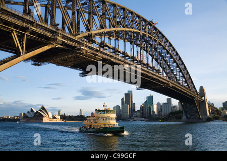 A ferry passes under the Sydney Harbour Bridge at Milson's Point.  Sydney, New South Wales, Australia Stock Photo