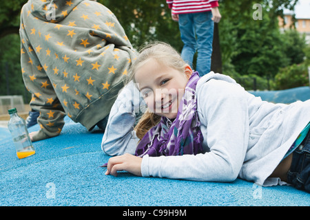 Germany, Berlin, Boy and girl lying on ground, smiling Stock Photo