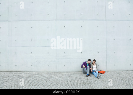 Germany, Berlin, Couple using laptop on stairway Stock Photo