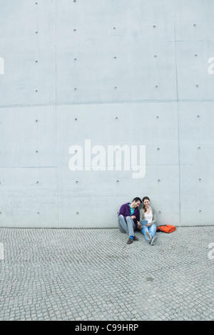 Germany, Berlin, Couple using laptop on stairway Stock Photo