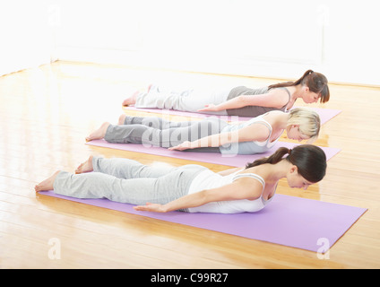 Germany, Hamburg, Yoga instructor and female trainee doing yoga exercise in gym room Stock Photo