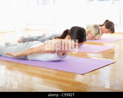 Germany, Hamburg, Yoga instructor and female trainee doing yoga exercise in gym room Stock Photo