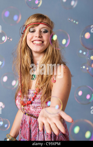 Young hippie woman with bubbles against grey background, smiling Stock Photo