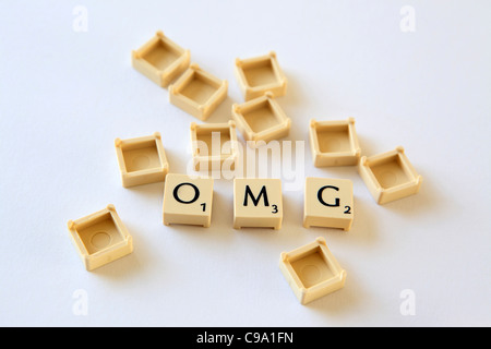 'OMG' spelled out in Scrabble letter tiles squares, sland txt texting chat speak, studio photograph Stock Photo