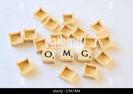 'OMG' spelled out in Scrabble letter tiles squares, sland txt texting chat speak, studio photograph Stock Photo