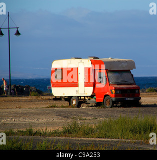 Camper van parked on waste ground in sunshine Stock Photo