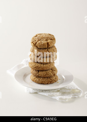 A stack of ginger snap cookies on a white plate Stock Photo