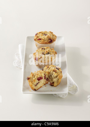 Three cranberry orange muffins on a white platter Stock Photo