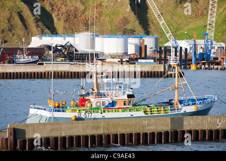 A fishing boat and oil storage tanks in Scrabster harbour, on Scotland's North Coast. Stock Photo