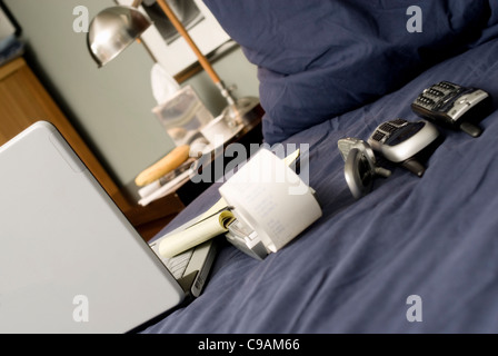 Bed with a laptop, three phones and breakfast. Shallow DOF. Stock Photo