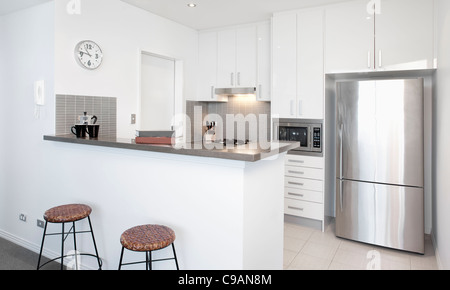 Modern white Kitchen in apartment with Polished Stainless Steel Appliances Stock Photo