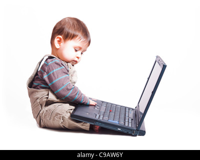 6 month baby boy sitting in front of laptop Stock Photo