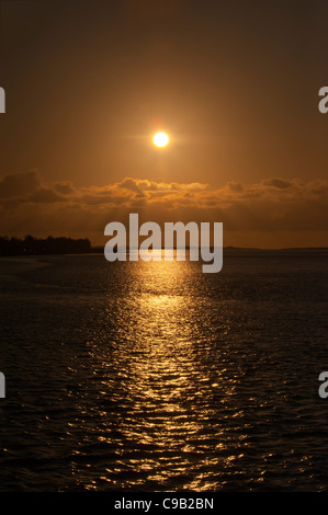 Sunset over the straits from Victoria docks Caernarfon Gwynedd North Wales Uk Stock Photo