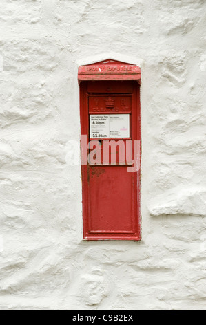 Rare historic Victorian red Royal Mail postbox set into whitewashed wall (flap opening mailbox close-up) - Hubberholme, North Yorkshire, England, UK. Stock Photo