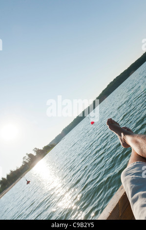 Man relaxing on a wooden pier by the water. Aland Island Finland Stock Photo
