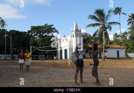 YOUNGSTERS CHAT ON THE BEACH AT PRAIA DO FORTE, BAHIA, BRAZIL Stock Photo