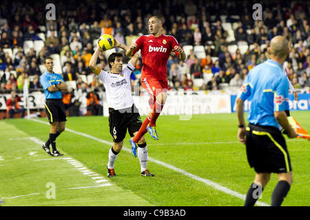 19/11/2011. Valencia, Spain  Football match between Valencia Club de Futbol and Real Madrid Club de Futbol, corresponding to 13th journey of Liga BBVA -------------------------------------  Karim Benzema from Real MAdrid jumps in front of David Albelda from Valencia CF as he tries to serve the ball Stock Photo