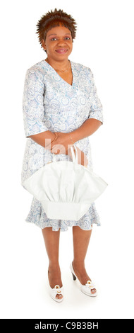 Beautiful African American lady in a beautiful dress and matching purse is smiling and looking at the camera. Stock Photo