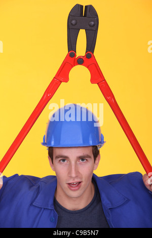 Man holding bolt-cutter over his head Stock Photo