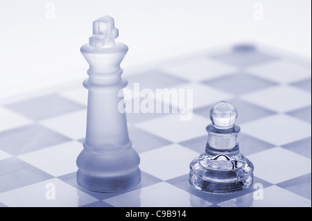 Glass chess. A pawn and a king. Blue toned. It is isolated on a white background. Stock Photo