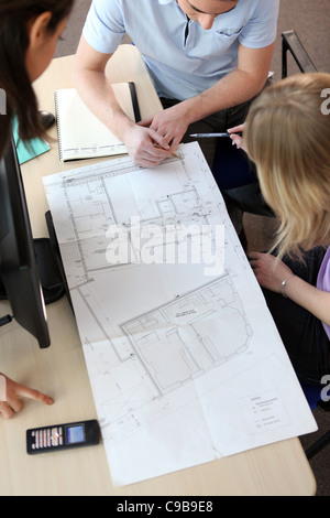 People looking at the layout of a house Stock Photo