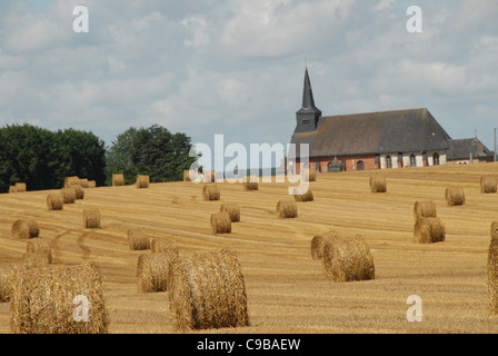 Harvested wheat field with corn balls rolled up near Yvetôt in the Pays de Caux of Normandy, France Stock Photo