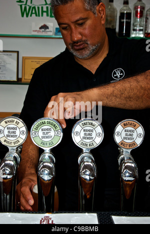 Publican pulling frosty pint of pale ale on tap from selection of beers at Wild on Waiheke brewery pub Stock Photo