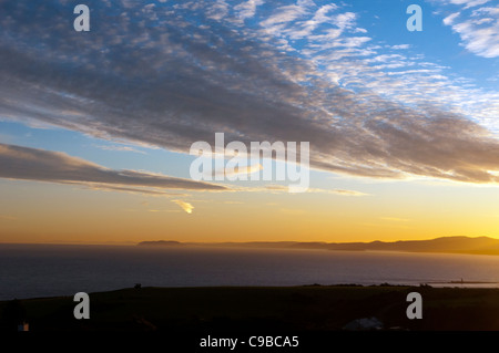 Moelfre bay anglesey north wales uk sunrise over mountains snowdonia range Stock Photo