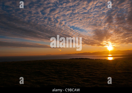 Sunrise over the snowdonia range across moelfre bay Anglesey North Wales Uk Stock Photo