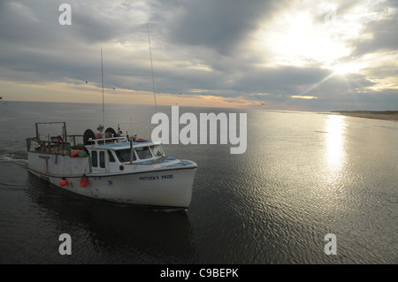 A fishing boat returns to the mooring in the morning to North Lake Harbor, Prince Edward Island after a night of fishing. Stock Photo