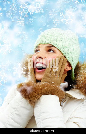 Pleasantly surprised young woman smiles looking up Stock Photo