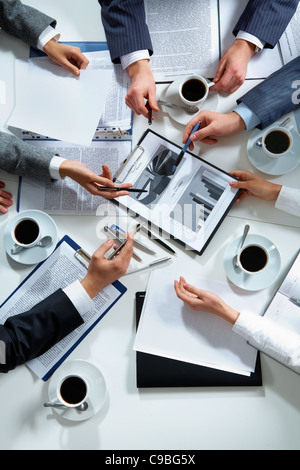 Close-up of business team hands over papers during discussion of a new project Stock Photo