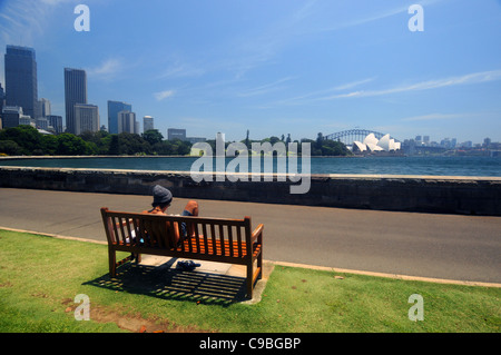 Studying on park bench on fine day, Royal Botanic Gardens, Sydney, NSW, Australia. No MR or PR Stock Photo