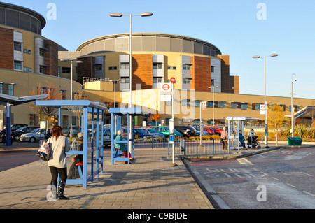 Bus stop & exterior of NHS Queens Hospital building & Maternity healthcare medical centre Romford London Borough of Havering East London England UK Stock Photo