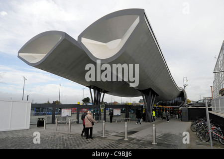 People at modern building & architecture design of cantilevered roof structure of public transport bus station Slough Berkshire England UK Stock Photo