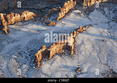 AERIAL VIEW. Sandstone outcrop in a snowy field. Chesler Park Peak, Canyonlands National Park, San Juan County, Utah, USA. Stock Photo