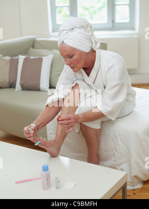 Senior woman painting toenails, close up Stock Photo