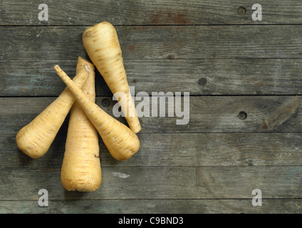 Parsnips with knife on wooden table Stock Photo