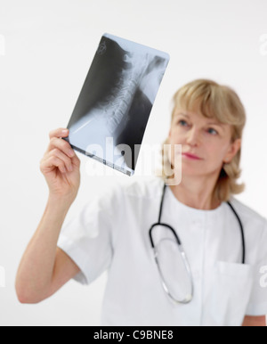 Mature female doctor examining x-ray Stock Photo