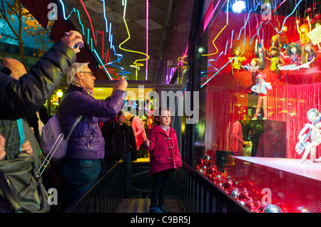 Paris, France, Families with Children, Looking, Enjoying in 'Galeries Lafayette' Department Store WIndows, Christmas Lights, Displays, at Night, taking pictures, city colourful Stock Photo