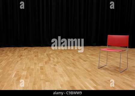 A directors chair on a stage with a black curtain in background Stock Photo
