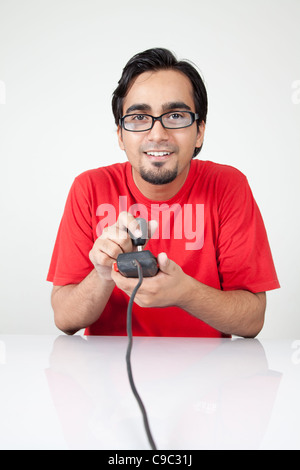 Nerd playing retro game holding joystick Stock Photo