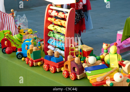 Brightly painted traditional wooden toys on a market stall in Winchester, Hampshire, England. Stock Photo