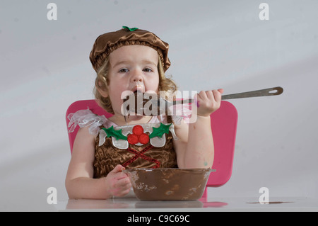 Young girl making a chocolate Christmas cake. Stock Photo