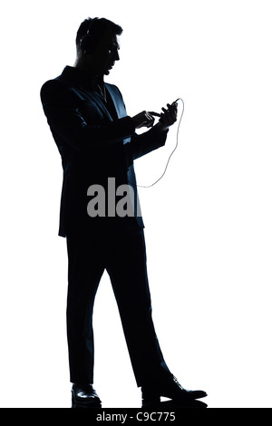 one caucasian man text messaging telephone listening to music full length silhouette in studio isolated white background Stock Photo
