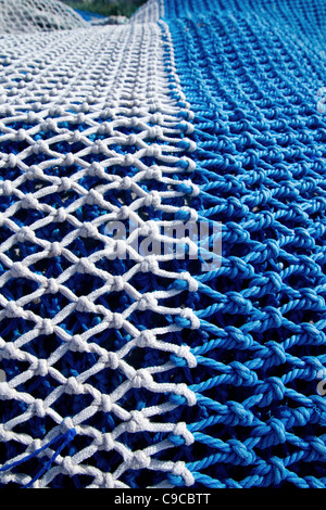 blue and white fishing nets with rope knots for trawling boats Stock Photo