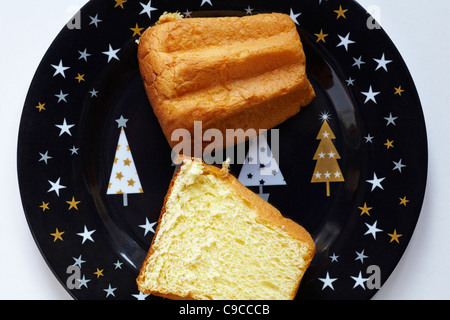 Pandoro Classico halved and placed on christmas plate set on white background Stock Photo