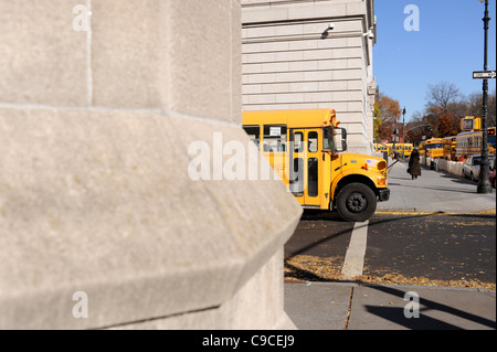 Yellow school bus driving through Central Park West Manhattan New York NYC USA America Stock Photo