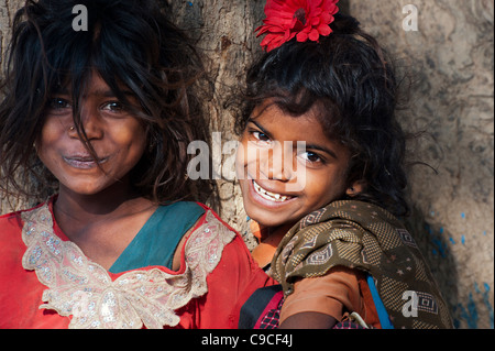 Poor Indian nomadic beggar girls laughing whilst hugging a tree and ...