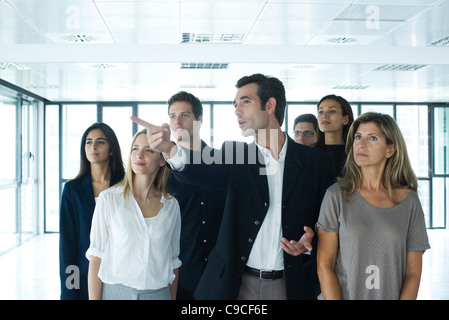 Real estate agent giving tour to business people in new office Stock Photo